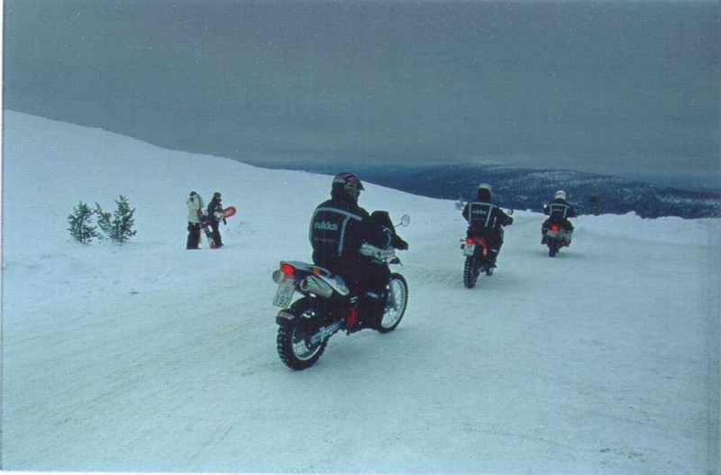 Snowboarders are surprised by heavy enduro bikers.