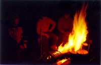 Evening at Peikkola. Timo melts the sausage, Kassu and Pekka are just staring at fire.